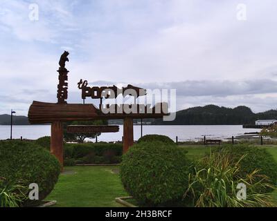 Blick auf das wunderschöne hölzerne Begrüßungsschild im Carrot Park, Port Hardy, Vancouver Island, umgeben von Büschen an bewölkten Tagen im Herbst. Stockfoto