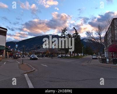 Wunderschöne Aussicht auf die Innenstadt von Jasper, die sich in den kanadischen Rocky Mountains befindet, im Abendlicht im Herbst mit vorbeifahrenden Autos und alten Gebäuden. Stockfoto