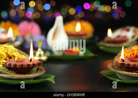 Diya oder Deep lit in Blattschüsseln auf Pattal oder Pattal Dona Katori, dekoriert mit Paan Shankh Roli Haldi und Blumen. Thema Für Diwali, Navratri Stockfoto