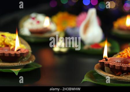 Diya oder Deep lit in Blattschüsseln auf Pattal oder Pattal Dona Katori, dekoriert mit Paan Shankh Roli Haldi und Blumen. Thema Für Diwali, Navratri Stockfoto