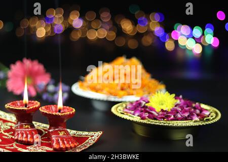 Tonlampe bekannt als Diya, Deep, Diyo, Deepa oder Deepam mit Göttin Füße Lakshmi Charan Beleuchtung mit Blumen und Bokeh Effekt. Shubh Deepawali Und Stockfoto