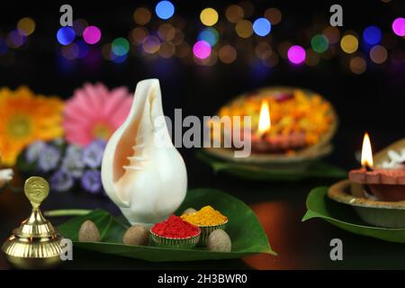 Zinnoberrot Roli Sindoor, Kurkuma Haldi Auf Betel Paan Blättern Und Shell Shankh. Tonöllampe Diya, Tief Oder Dia Im Hintergrund Beleuchtet. Thema Für Diwali, Nav Stockfoto