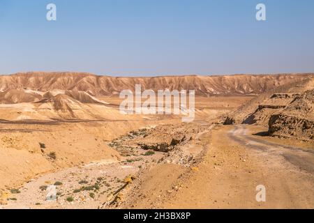 Rocky Mountains in Israel neben einer staubigen und unbefestigten Schotterstraße durch die trockene Judäische Wüste im Midbar Yehuda. Fahren Sie vom Small Crater zum Highway #90 Stockfoto