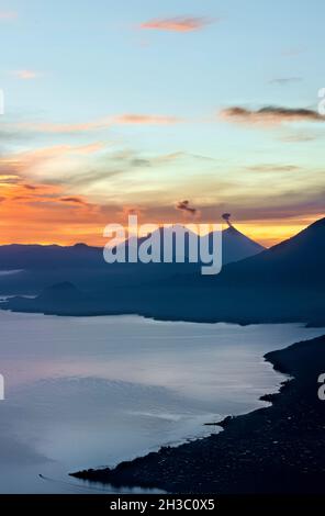 Sonnenaufgang über dem Lake Atitlan und Fuego, Vulkan, Lago Atitlan, Guatemala Stockfoto