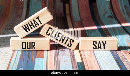 Was unsere Kunden sagen, Text auf Holzblöcken und buntem Hintergrund Stockfoto