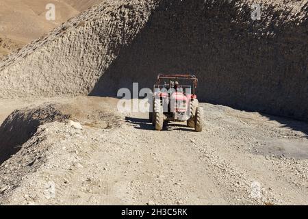 Kagbeni, Mustang District, Nepal - 19. November 2016: Der Traktor fährt entlang der Straße in den Bergen. Schotterstraße von Jomsom nach Muktinath in Stockfoto