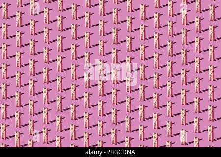 Holzzapfen auf pastellrosa Hintergrund. Draufsicht. Minimalistisches abstraktes Modekonzept. Stockfoto