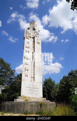 WWI, San Martino del Carso, Friaul Julisch Venetien, Italien. In der Nähe des Grabens mit dem Namen 'trincea delle frasche' kann man den Gedenkstein sehen, der Filippo Corridoni gewidmet ist. Er war vor dem Krieg Gewerkschaftsvertreter gewesen und starb in diesem Viertel am 23. Oktober 1915. Das 23 Meter hohe Denkmal wurde 1933 vom Bildhauer Francesco Ellero errichtet, um dem Willen von Benito Mussolini zu entsprechen, der an seinen alten Freund, der im Krieg gestorben war und seinen Körper ohne Identifizierung verloren hatte, erinnern wollte. Die faschistische Skulptur, das Denkmal Schuhe die Symbole jener Epoche : der offene römische Hagel, der Osten Stockfoto