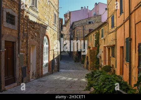 Eine schmale Gasse im historischen Zentrum des mittelalterlichen Dorfes im Sommer, Castagneto Carducci, Livorno, Toskana, Italien Stockfoto