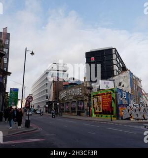 Great Eastern Street in Shoreditch mit den berühmten Lets anbeten und ertragen einander Schild und U-Bahn-Züge über einem Gebäude. London Stockfoto