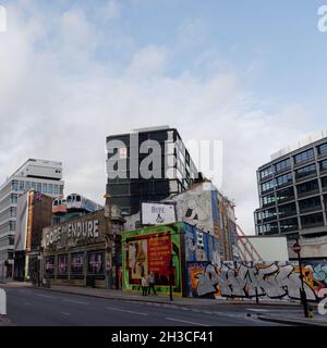 Great Eastern Street in Shoreditch mit den berühmten Lets anbeten und ertragen einander Schild und U-Bahn-Züge über einem Gebäude. London Stockfoto