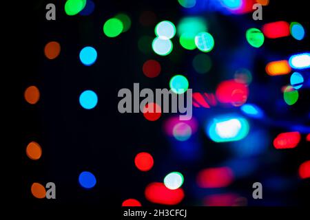 Dunkler Hintergrund mit vielen verschiedenen farbigen Kreisen. Bokeh-Effekt. Dekorativer Hintergrund Stockfoto