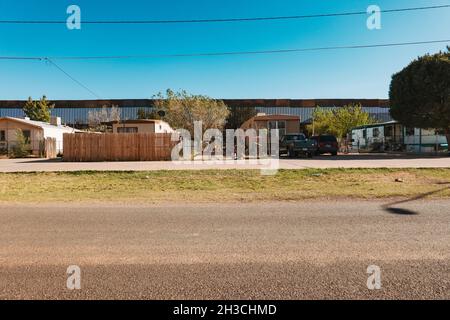 Die US-mexikanische Grenzmauer dient gleichzeitig als Hinterhofzaun eines Hauses in der Kleinstadt Naco, Arizona Stockfoto