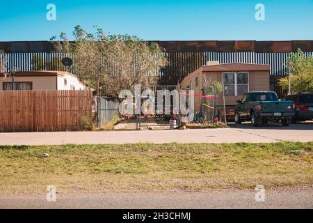 Die US-mexikanische Grenzmauer dient gleichzeitig als Hinterhofzaun eines Hauses in der Kleinstadt Naco, Arizona Stockfoto