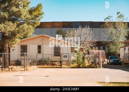 Die US-mexikanische Grenzmauer dient gleichzeitig als Hinterhofzaun eines Hauses in der Kleinstadt Naco, Arizona Stockfoto