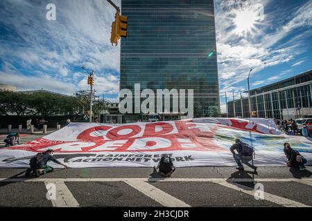 USA. Oktober 2021. Die Teilnehmer sahen, wie sie ein Banner bei dem Protest hielten. Im Vorfeld des Klimagipfels COP26 in Glasgow hat sich eine große Koalition aus Aktivisten und führenden Vertretern der Gemeinschaft im ganzen Land zusammengeschlossen und einen starken Standpunkt gegen den Klimawandel gefordert. In New York City entfalteten Aktivisten des Rainforest Action Network einen riesigen „CODE RED!“ Banner vor dem Hauptquartier der Vereinten Nationen. (Foto von Erik McGregor/Sipa USA) Quelle: SIPA USA/Alamy Live News Stockfoto