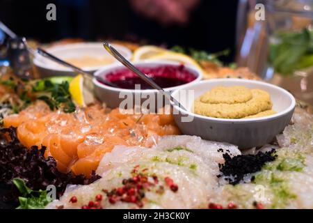 Lachsfilet aus Grawlachs, Weißfischfilet, Hummus, Sektgelee, Sauce aus schwarzer Johannisbeere und Zitrone. Köstliches, professionell aussehendes Essen und Snacks Catering. Stockfoto