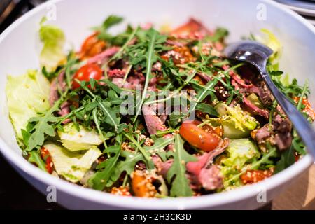Frischer grüner Salat mit Tomaten. Köstliche, professionell aussehende Speisen und Snacks, die bei einer Catering-Veranstaltung oder einem Party-Buffet serviert werden. Stockfoto