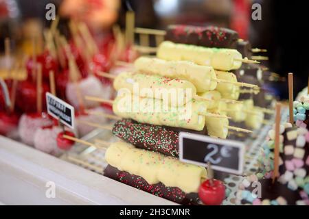 Äpfel dip in Schokoladenglasur und kleine Marshmallows auf Weihnachtsmarkt verkauft. Bonbons, Süßigkeiten und Desserts auf Weihnachten. Winter Urlaub im Freien. Stockfoto