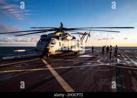 211026-N-PC065-1012 ATLANTIK (OKT 26, 2021) Marinesoldaten, die dem Marine Medium Tiltrotor Squadron (VMM) 263 (verstärkt) zugewiesen wurden, entfalten die Rotorblätter eines Super-Hengsthubschraubers CH-53E, der an VMM-263 (rein) befestigt ist, während der Vorflugkontrollen auf dem Flugdeck des Amphibientransportschiffes USS Arlington (LPD 24) der San Antonio-Klasse, 26. Oktober 2021. Arlington ist im Atlantischen Ozean unterwegs, um Amphibiengeschwader und Marine Expeditionary Unit Integration (PMINT) zu unterstützen. PMINT bietet die Möglichkeit, in einem integrierten Umfeld für amphibische und maritime Operationen mit eingeschifften Marineinfanteristen zu trainieren Stockfoto