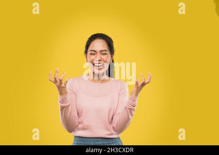 Schöne junge Frau, die aufgeregt mit Pfoten schreit und zwei Hände offen hat Stockfoto