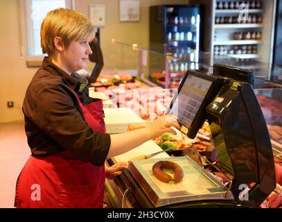 Daaden, Deutschland. Oktober 2021. Auszubildende Sara Katwinkel betreibt die Wurstwaage in der Metzgerei von Dirk Schmidt. Das Unternehmen in Daaden (Kreis Altenkirchen) beschäftigt 30 Mitarbeiter, davon 5 Auszubildende. (An dpa: 'Speeddating and Azubi Car - Creative advertising for New Blood'). Quelle: Thomas Frey/dpa/Alamy Live News Stockfoto