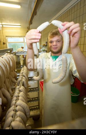 Daaden, Deutschland. Oktober 2021. Auszubildender Nick Mann hängt Würste in der Metzgerei von Dirk Schmidt. Das Unternehmen in Daaden (Kreis Altenkirchen) beschäftigt 30 Mitarbeiter, davon 5 Auszubildende. (An dpa: 'Speeddating and Azubi Car - Creative advertising for New Blood'). Quelle: Thomas Frey/dpa/Alamy Live News Stockfoto