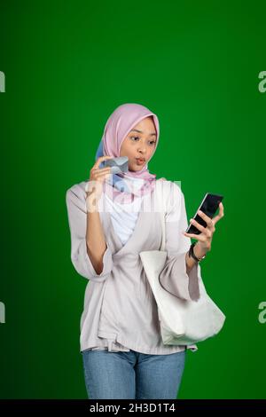 Frau in Hijab glücklich mit Handy für Videoanruf Stockfoto