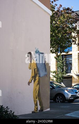 The Garbage man - Trompe-l'oeil Wandbild von Mann in Hazmat Anzug sammeln einen Müll (und Ausländer), von Greg Brown, in 136 Hamilton Ave, Palo Alto, Kalifornien Stockfoto