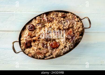 Risotto ai Funghi, Pilzgericht, von oben auf einem rustikalen Holztisch geschossen Stockfoto