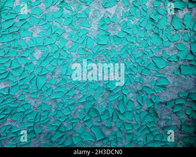 Die Farbe blättert blau an der Wand ab. Verwitterte, rauh lackierte Oberfläche mit Rissen- und Abschälungsmustern. Textur für Hintergrund und Design. Stockfoto