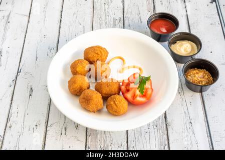 Servieren von runden Hähnchenkroketten mit Tomaten- und Tomatensaucen, Mayonnaise und dijon-Senf zum Eintauchen Stockfoto