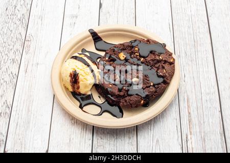 Schokoladenkekse mit Haselnussportionierung und einer Kugel Vanilleeis mit Schokoladensirup Stockfoto