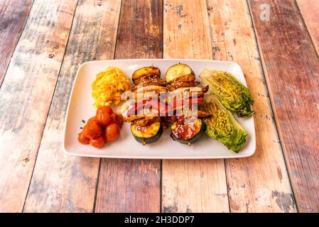 HEURA Spieße mit Paprika und Zucchini mit gebrochenem Herzen, Krautsalat und gerösteten Kirschtomaten mit Teriyaki-Sauce Stockfoto