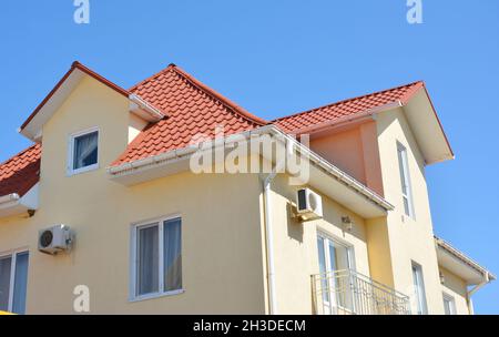 Nahaufnahme des Problembereichs des Dachrinnen-Rohrleitungssystems des Hauses. Dachrinne einbauen und reparieren. Stockfoto