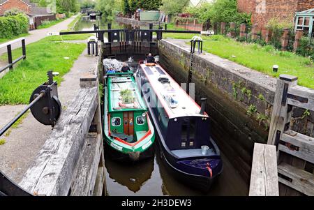 Zwei schmale Kanalboote mit den Namen „Cushie“ und „Judith n me“ verlassen die Schleuse 78 auf dem Schleusenflug von Wigan auf dem Leeds- und Liverpool-Kanal 28.5.2021 Stockfoto