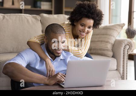 Glückliches junges afroamerikanisches Paar mit Computer. Stockfoto