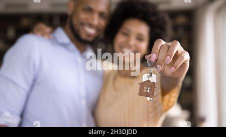 Nahaufnahme der Schlüssel in den Händen des verschwommenen afrikanischen Paares. Stockfoto