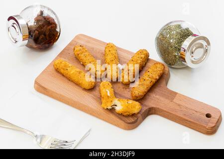 Vorspeisenbrett aus gebratenen Mozzarella-Sticks mit Oregano und getrockneten Tomaten aus der Dose Stockfoto