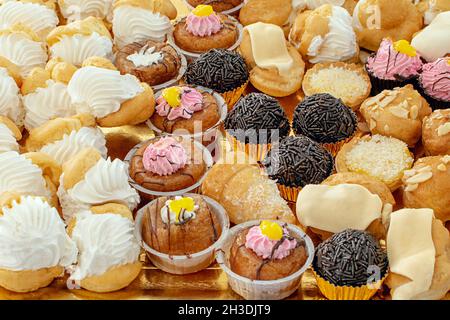 Bild von Cupcakes in großen Mengen, mit Zerstoßen von Creme, Schokoladentrüffel, Mandeln und Erdbeercreme Stockfoto