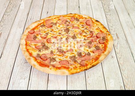 Tolle Pizza mit bologna Mortadella mit gebratenem Hackfleisch, geschnittener Salami und viel Mozzarella-Käse Stockfoto