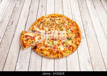 Pizza mit Pilzen, grünen und roten Paprika, Schinken, weißen Zwiebeln und gut geröstetem Mozzarella-Käse Stockfoto