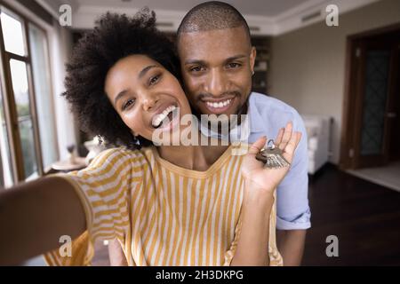 Fröhliches junges afroamerikanisches Paar, das Schlüssel zeigt. Stockfoto