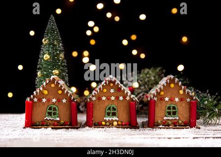 Weihnachts Lebkuchenhaus und Weihnachtsbeleuchtung auf Holztisch Stockfoto