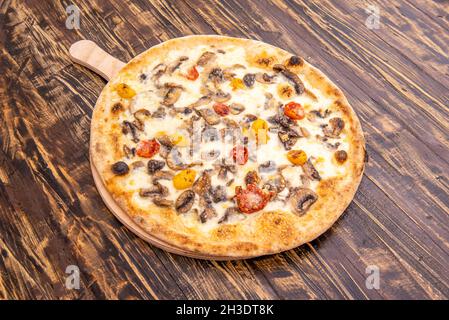 Pilzpizza mit verschiedenen Kirschtomaten, viel Mozzarella-Käse und dünnem Weizenmehlteig Stockfoto