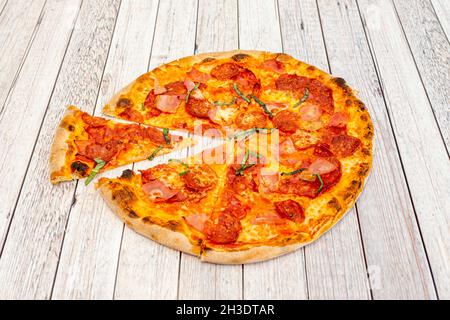 Meat Lovers Pizza mit Pepperoni, Basilikum, Chorizo und gut gebackenem Schinken Stockfoto