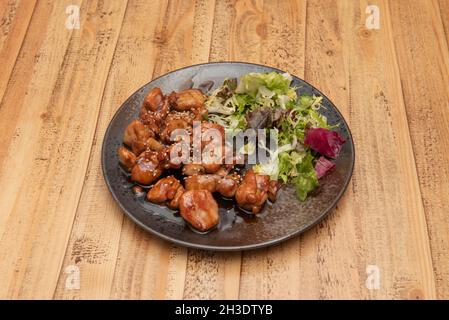 Gehacktes Huhn mit japanischer Teriyaki-Sauce, garniert mit Salat und Sesamsamen und Mohnblumen Stockfoto