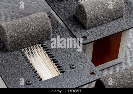 Flache Hochtöner aus Folienband vor grauem Hintergrund. Foto aufgenommen unter künstlichem Licht Stockfoto