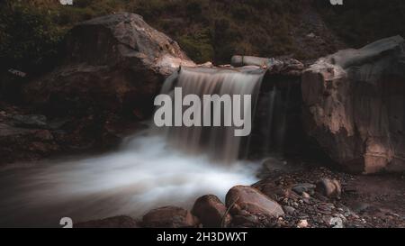 Langzeitaufnahme eines Stromes, der durch einen Wald läuft Stockfoto