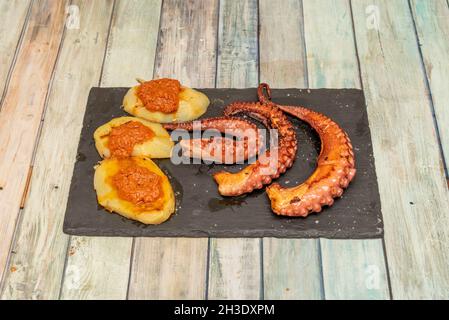 Gegrillte Kraken-Tentakeln mit Meersalz, Paprika de la Vera und Kartoffeln mit Tomatensauce Stockfoto